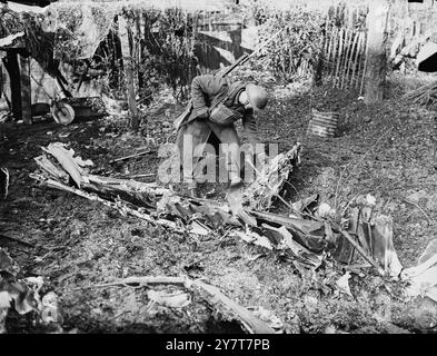 BOMBARDIER NAZI ABATTU LORS D'UNE VASTE ATTAQUE NAZIE SUR LA RÉGION DE LONDRES. Photo montre:- Un soldat examinant l'épave d'un bombardier ennemi abattu dans le jardin de Londres lors de l'une des attaques nazies les plus féroces sur la région de Londres, laissant un cratère ro marquer sa fin 17 avril 1941 Banque D'Images