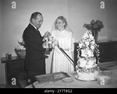 OFFICIER DE MARINE AUSTRALIEN SE MARIE À LONDRES LIEUTENANT COMMANDER V.A.T. SMITH D.S.C. RAN (ROYAL AUS NAVY) GAI 30. OCT 1944Le mariage entre Lieut. Comm. V.A.T. Smith D.S.C. de Sydney Royal Australian Navy et Mlle Nanette Harrison de Londres ont eu lieu à l'église George's Church, Hanover Sq. Londres. M. Sidney Cotton, un homme bien connu de Sydney, a donné la mariée. Spectacles de photos : la mariée et le marié coupant le gâteau de mariage à la réception après la cérémonie. 30 octobre 1944 Banque D'Images