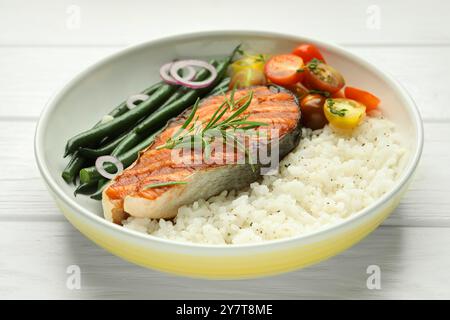 Savoureux steak de saumon grillé avec riz et légumes sur une table en bois blanc, gros plan Banque D'Images