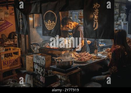 Chef japonais préparant des yakitori dans un restaurant traditionnel Banque D'Images