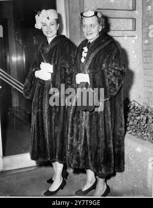 Vêtues à l'identique de manteaux de fourrure, l'actrice américaine Grace Kelly (à gauche) et sa mère Mme John B Kelly de Philadelphie, arrivent au domicile New-yorkais de Mme Blair Richardson pour une douche nuptiale en l'honneur de Mlle Kelly qui épousera le Prince Rainier III de Monaco le 19 avril. 30 mars 1956 Banque D'Images