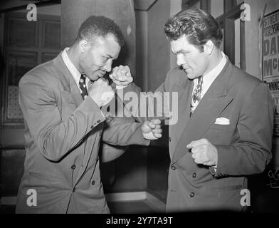 RAMASSER DES POINTS 16 mai 1950 Fistful of utiles astuces for Mel Brown of America (à gauche) de l'ex-champion du monde des poids lourds légers Freddie Mills lors d'une réunion de costume lounge au gymnase Dales à Brixton, Londres. Brown, surnommé le Jinx en raison de son talent étrange d'arrêter les concurrents au championnat, a récemment battu les deux concurrents pour le titre britannique des poids légers et lourds, Mark Hart et Dennis Powell. Banque D'Images