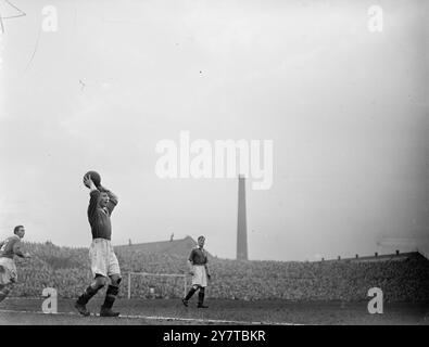 OFFICE BOY FAIT SES DÉBUTS AVEC MANCHESTER UNITED 16 avril 1950 Jeffrey Whitefoot, âgé de seize ans, de Cheadle, dans le Cheshire, a laissé son stylo et son tabouret dans les bureaux du Manchester United Football Club, a mis les couleurs du club et est sorti à Old Trafford Ground pour réaliser que chaque garçon rêve et joue un match de première division. Jeffrey, diplômé de l'école de football à la First Division en un an, a fait ses débuts dans le match contre Portsmouth et bien que son équipe ait été battue 2-0 les critiques l'ont félicité. Jeffrey jouait à la moitié droite. Images : Jeffrey Whitefoot prend un lancer pendant le match Banque D'Images