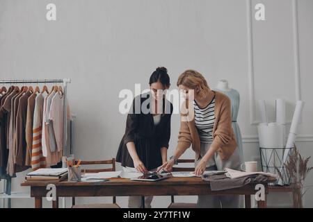 Deux créatrices de mode féminines confiantes travaillant en atelier ensemble Banque D'Images