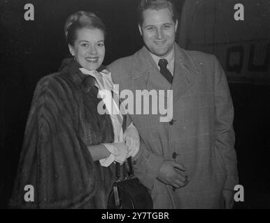 MAISON AVEC LE SOURIRE JANIS PAIGE , actrice américaine de cinéma , fait éclater un sourire d'adieu comme avec son mari, M.R. Frank Martinelli, elle part pour la maison dans le paquebot étoile blanche Cunard ' Queen Elizabeth ' à Southampton. Le 'Q.E.' navigue aujourd'hui. 16 novembre 1949 Banque D'Images