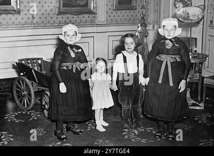 PRINCESSE ET PAYSANS main dans la main avec deux petites filles dans le costume traditionnel du quartier de staphorst des pays-Bas sont la princesse MARIJKE (à gauche) et la princesse Margriet , deux des quatre jeunes filles de la reine Juliana des pays-Bas et du prince Bernhard . Jentje PIELEMAN (extrême gauche) et JANTE KUYERS (extrême droite) rendaient visite aux princesses pour les présenter avec le chariot paysan vu en arrière-plan. 14 novembre 1949 Banque D'Images