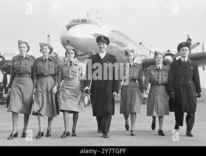 YEUX SUR LE PRIX ces membres du Junior Air corps féminin, souriant avec détermination, marchant à travers l'aire de trafic de l'aéroport de Londres avec les stewards de British Overseas Airways après avoir effectué une visite d'inspection à un avion de ligne de constellation. L'avion est similaire à celui dans lequel un membre chanceux du corps volera vers l'Australie au début de l'année prochaine. Le vol, par B.O.A.C./ Qantas, est le prix offert par le corps au gagnant du concours ouvert à tout membre âgé de 19 à 25 ans. 3 novembre 1949 Banque D'Images