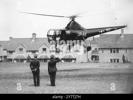 SUR LE POINT DE FAIRE L'HISTOIRE DE BATEAU EN HÉLICOPTÈRE. À l'intérieur de l'hélicoptère que les deux offcers de la RAF saluent lorsqu'il arrive à la base aérienne de Mount Batten se trouvait le capitaine E R McLean, JNR, commandant du croiseur américain Columbus. Le capitaine McLean avait volé du Columbus dans le Hamoaze, près de Plymouth, Devon, pour payer un appel officiel au vice-maréchal Spencer de l'Air, et lorsque l'hélicoptère a atterri au mont Batten, l'histoire a été faite. C'était la première fois qu'un hélicoptère atterrissait à la base aérienne, qui est devenue célèbre pour les travaux de sauvetage de Sunderland effectués à partir de là pendant le Banque D'Images