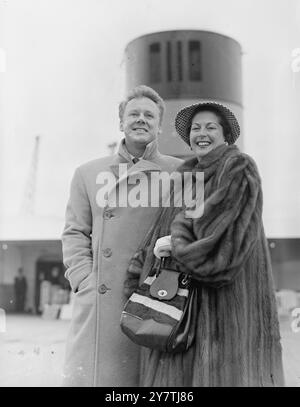 Southampton : L'acteur Van Johnson , avec son col de manteau retourné pour se protéger contre le vent fort , se promène sur le pont du paquebot Queen Elizabeth avec sa femme. Il retourne en Amérique après avoir assisté à la première de son film ' Battleground ' au Théâtre Empire du .22 mars 1950 Banque D'Images