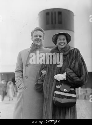 Southampton : L'acteur Van Johnson , avec son col de manteau retourné pour se protéger contre le vent fort , se promène sur le pont du paquebot Queen Elizabeth avec sa femme. Il retourne en Amérique après avoir assisté à la première de son film ' Battleground ' au Théâtre Empire du .22 mars 1950 Banque D'Images