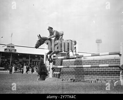 Prince Bernhard saute à White CityLodon : sur un saut en hauteur au stade Whte City va Prince Bernhard des pays-Bas , en compétition dans le 30ème salon International du cheval . Le cheval qu'il monte , et qui prend le saut en belle style est Véronique. 23 July1949 Banque D'Images