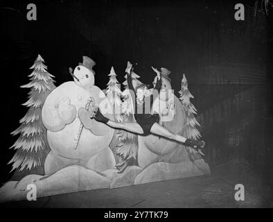 Peggy Wallace de Brooklyn, New York - championne du monde de patinage artistique 1947 - fait les ' splits ' sur fond de bonhommes de neige impassible dans les vanités de patinage à roulettes d'un million de dollars de 1949 ' mis en scène à l'Empire Pool , Wembley11 juin 1949 Banque D'Images