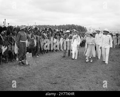 Les guerriers swazis sifflent salutation à la famille Royale une masse de guerriers swazis , 4 000 forts, avec des gaines en peau de léopard, des assegais , des nobkerries et des boucliers en peau de boeuf ont salué le roi George avec l'étrange sifflet entre les dents serrées qui est leur forme du salut royal lorsque la famille royale a visité Goedegun au Swaziland pendant leur tournée sud-africaine. PHOTOS MONTRE : le Roi saluant en réponse à la salutation des guerriers swazis . Sur la droite se trouve la reine Elizabeth et sur la gauche se trouve le chef suprême Sobhuza Dlamini II 31 mars 1947 Banque D'Images