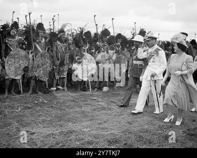 Les guerriers swazis sifflent salutation à la famille Royale une masse de guerriers swazis , 4 000 forts, avec des gaines en peau de léopard, des assegais , des nobkerries et des boucliers en peau de boeuf ont salué le roi George avec l'étrange sifflet entre les dents serrées qui est leur forme du salut royal lorsque la famille royale a visité Goedegun au Swaziland pendant leur tournée sud-africaine. PHOTOS MONTRE : le Roi saluant en réponse à la salutation des guerriers swazis . Sur la droite se trouve la reine Elizabeth et sur la gauche se trouve le chef suprême Sobhuza Dlamini II 31 mars 1947 Banque D'Images