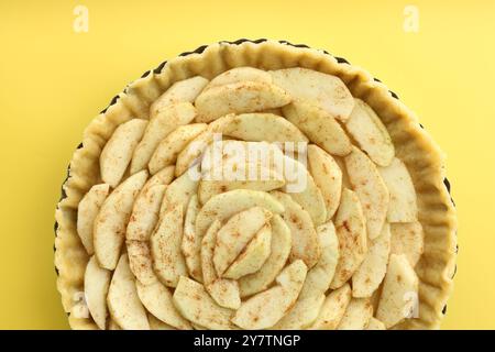 Tarte aux pommes maison crue sur fond jaune, vue de dessus Banque D'Images