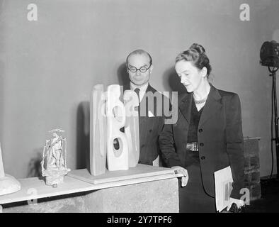 La sculptrice Barbara Hepworth, née dans le Yorkshire, aujourd'hui à St Ives, en Cornouailles, montre à Sir John Rotherstein, directeur de la Tate Gallery, son interprétation de « The Unknown Political Prisoner », qui a été choisie comme l'une des douze œuvres pour représenter la Grande-Bretagne au concours international de sculpture. Il y a 3500 candidatures de 57 pays. La Grande-Bretagne a eu le deuxième plus grand nombre de participations et le jury national britannique en a sélectionné 12 pour compléter la finale internationale.14 janvier 1953 Banque D'Images