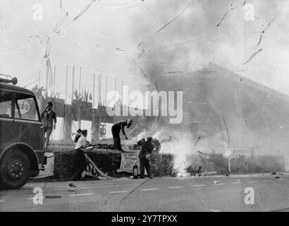 MERCEDES TEAM ATTEND LA DECISIONLa Crack Mercedes Team dont l'une des voitures s'est écrasée devant la tribune principale du Mans causant 84 morts dans la box Mercedes pour la décision du quartier général quant au retrait des deux autres Mercedes le 11 juin 1955. Sur la gauche, debout avec les bras pliés et vêtu d'une combinaison blanche se trouve le coureur argentin ACE, Fangio. Par la suite, l'équipe Mercedes a été retirée. Circuit de la Sarthe au Mans, France. 12 juin 1955 Banque D'Images