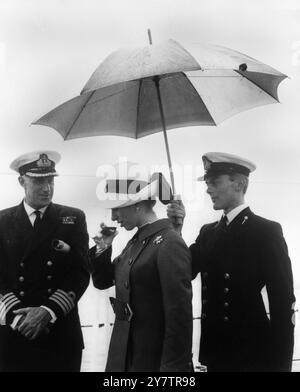 SAR la Princesse Anne envisage un verre de 'grog' - rhum naval - avant de goûter la boisson traditionnelle de la Royal Navy lors de sa visite au HMS Eastbourne au large de Torbay, Devon, Angleterre, aujourd'hui, alors que le 'grog' était émis. - La Princesse, avec SM la Reine, le Prince Philip et le Prince de Galles, est en visite de deux jours sur les navires de la flotte occidentale maintenant ancrés au large de Torbay. - 28 juillet 1969 Banque D'Images