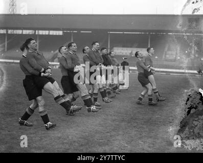 PORTANT TOUT DEVANT EUX - L'ÉQUIPE BELGE DE FOOTBALL VA S'ENTRAÎNER AU WHITE CITYL'équipe belge de football de l'Association nouvellement arrivée dans ce pays pour jouer contre une équipe d'Angleterre à Wembley le 19 janvier, a été entrée dans un entraînement rigoureux au White City Stadium. Sauter grenouille, ramasser un dos, et les exercices de portage de poids sont parmi les secousses physiques qui maintiennent ces jeunes hommes dans le rose de condition pour leurs prochains concours. Après leur match contre l'Angleterre, les Belges rencontreront une équipe écossaise à Hampden Park, Glasgow le 23 janvier. Photos montre : la voiture de l'équipe belge Banque D'Images