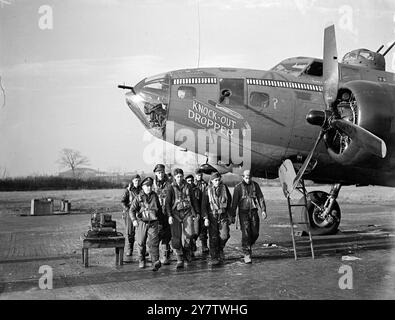 « KNOCK OUT DROPPER » TIENT LA TÊTE DANS LE MARATHON DE BOMBARDEMENT DE FORTERESSE VOLANTE montre : l'équipage de la forteresse volante « Knock Out Dropper » marchant vers leur avion record. Quarante-neuf bombes - une pour chaque mission - sont peintes sur le fuselage. À gauche de la première rangée se trouve le capitaine George T. Mackin, de Portland, Oregon, le copilote, à côté de lui, lieutenant Malcolm E. Brown, pilote originaire de Sylva, Caroline du Nord. 13 novembre 1943 Banque D'Images