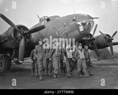 « KNOCK OUT DROPPER » TIENT LA TÊTE DANS LE MARATHON DE BOMBARDEMENT DE FORTERESSE VOLANTE montre : l'équipage de la forteresse volante « Knock Out Dropper » marchant depuis le bombardier après avoir participé à une mission en territoire occupé ennemi. 13 novembre 1943 Banque D'Images