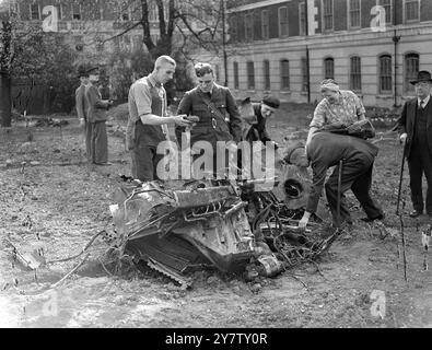 BOMBARDIER NAZI ABATTU DANS LA RUE DE LONDRES deux bombardiers allemands ont été abattus dans la région de Londres lors du «blitz» renouvelé, l'un des pires depuis le début de la guerre. L'un d'eux a été descendu dans une rue de la région de Londres et l'épave a été éparpillée sur une vaste zone. Photo montre : épave du bombardier allemand dans la rue de Londres où est tombé, en cours d'examen par des aviateurs. 18 avril 1941 Banque D'Images