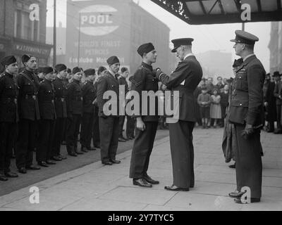 CADET DE L'AIR RÉCOMPENSÉ PAR LE VICE-MARÉCHAL DE L'AIR POUR AVOIR SAUVÉ UNE FEMME ÂGÉE DE LA MAISON BOMBARDÉE. Le cadet de l'air Harry Richard Smith de Willesden, âgé de 17 ans, anciennement un éclaireur du roi, et un ouvrier dans une usine d'avions, a reçu la médaille Cadet Gallantry par le vice-maréchal de l'air Sir charles Loncroft à l'hôtel de ville de Paddington. Le cadet de l'air Smith a sauvé une femme âgée d'une maison bombardée alors que les murs s'effondraient et menaçaient de s'effondrer à tout moment les piégeant tous les deux. Photo montre : le vice-maréchal de l'air Sir Charles Loncroft épingle la médaille sur la poitrine du cadet de l'air Harry Richard Smith. 2 février 1941 Banque D'Images