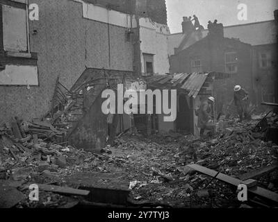 MAISONS ENDOMMAGÉES PENDANT LE RAID DE JOUR SUR LA RÉGION DE LONDRES. Des bombes ont été larguées sur la région de Londres et certaines maisons ont été endommagées lorsque des raids allemands uniques ont effectué des raids de jour sur la région de londres. Photo montre : un gardien transportant de la nourriture dans un panier d'une maison endommagée. Sur la gauche, l'escalier est toujours debout. BlackBerry Lane, tottenham 28 janvier 1941 Banque D'Images