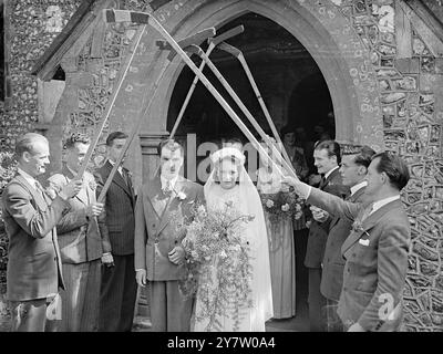 JOUEUR DE HOCKEY SUR GLACE DE WEMBLEY MARIÉ DANS LE SUSSEX Freddie Sutherland, joueur canadien de hockey sur glace de Wembley, s'est marié à l'église St John the Baptist de Findon, près de Worthing, Sussex, avec Mlle Joan McGlennen de Findon. Photos : Freddie Sutherland et son épouse quittent l'Église par une arche de bâtons de hockey tenus par des joueurs de Wembley. Il s'agit de John Oxley, Arthur Green, Joe Beaton, Doug Wilson, Frankie Green et John Murray. 25 juillet 1946 Banque D'Images