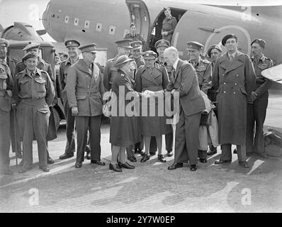 LES TROUPES DU PREMIER EMPIRE ARRIVENT POUR PRENDRE PART AU DÉFILÉ DE LA VICTOIRE DE LONDRES - - les hommes et les femmes du service sud-africain et rhodésien qui prendront part au défilé du jour de la victoire de Londres le 8 juin, sont arrivés par avion à l'aéroport de Blackbushe, Camberley, Surrey. Ils ont été accueillis par M. S. M. Lanigan O'Keefe, Haut Commissaire pour la Rhodésie du Sud. - Photos : M. Lanigan O'Keefe serrant la main de l'inspecteur I Bates, une femme inspectrice de la police sud-africaine britannique, à l'arrivée du groupe à l'aérodrome de Blackbushe, Surrey. Également dans l'image sont le major général W H E Poole CB, CBE, DSO d'Afrique du Sud et Brigadie Banque D'Images