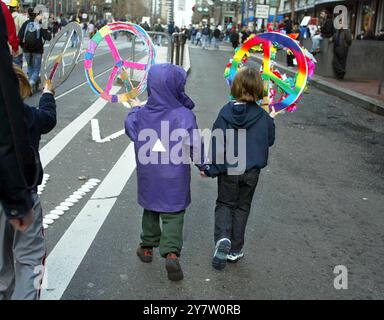 San Francisco, Calif--deux jeunes manifestants se tiennent la main en portant des signes de paix le dimanche 16 février 2003, alors qu’ils rejoignent des milliers d’activistes dans une marche anti-guerre le long de Market Street. La marche de protestation de San Francisco, organisée un jour après des rassemblements similaires dans d'autres villes du monde, a commencé à Justin Herman Plaza et a descendu Market Street avant de se terminer au Civic Center Plaza. Banque D'Images