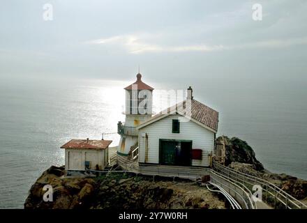 Point Reyes, Calif.,-- les phares de point Reyes vieux de 132 ans se sont accrochés à la mer battue comme il a été exposé au brouillard, au vent et au soleil alors que la balise et la corne de brouillard avertissent les mers. La lentille originale du phare a été conçue en 1823 par un ingénieur français désenchanté, Augustine Fresnel. Outre l'utilisation maritime, son invention qui concentrait la lumière rayonnante dans un faisceau horizontal, a été construite en 1870. Vingt-quatre panneaux verticaux dans la lentille grossissent la lumière à travers 1 032 prismes de cristal. Les rideaux sont fermés autour de la lentille chaque jour pour empêcher les rayons du soleil de commencer f Banque D'Images