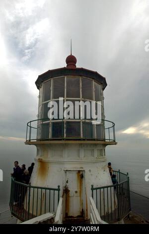 Point Reyes, Calif.,-- les phares de point Reyes vieux de 132 ans se sont accrochés à la mer battue comme il a été exposé au brouillard, au vent et au soleil alors que la balise et la corne de brouillard avertissent les mers. La lentille originale du phare a été conçue en 1823 par un ingénieur français désenchanté, Augustine Fresnel. Outre l'utilisation maritime, son invention qui concentrait la lumière rayonnante dans un faisceau horizontal, a été construite en 1870. Vingt-quatre panneaux verticaux dans la lentille grossissent la lumière à travers 1 032 prismes de cristal. Les rideaux sont fermés autour de la lentille chaque jour pour empêcher les rayons du soleil de commencer f Banque D'Images