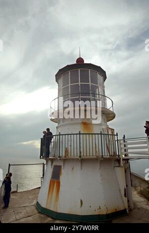 Point Reyes, Calif.,-- les phares de point Reyes vieux de 132 ans se sont accrochés à la mer battue comme il a été exposé au brouillard, au vent et au soleil alors que la balise et la corne de brouillard avertissent les mers. La lentille originale du phare a été conçue en 1823 par un ingénieur français désenchanté, Augustine Fresnel. Outre l'utilisation maritime, son invention qui concentrait la lumière rayonnante dans un faisceau horizontal, a été construite en 1870. Vingt-quatre panneaux verticaux dans la lentille grossissent la lumière à travers 1 032 prismes de cristal. Les rideaux sont fermés autour de la lentille chaque jour pour empêcher les rayons du soleil de commencer f Banque D'Images