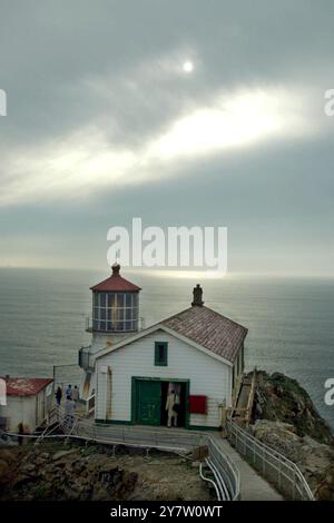 Point Reyes, Calif.,-- les phares de point Reyes vieux de 132 ans se sont accrochés à la mer battue comme il a été exposé au brouillard, au vent et au soleil alors que la balise et la corne de brouillard avertissent les mers. La lentille originale du phare a été conçue en 1823 par un ingénieur français désenchanté, Augustine Fresnel. Outre l'utilisation maritime, son invention qui concentrait la lumière rayonnante dans un faisceau horizontal, a été construite en 1870. Vingt-quatre panneaux verticaux dans la lentille grossissent la lumière à travers 1 032 prismes de cristal. Les rideaux sont fermés autour de la lentille chaque jour pour empêcher les rayons du soleil de commencer f Banque D'Images