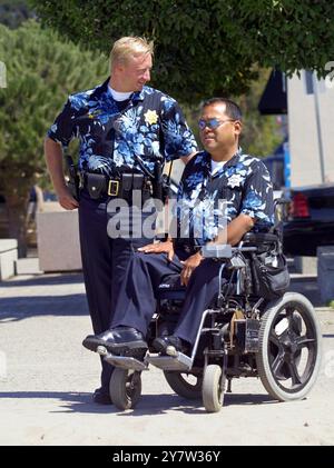 Capitola, Californie : L'officier Andrew Dally, et l'officier de police de stationnement, Ben Irao, avec le département de police de Capitola, discutent à l'Esplanade à côté de la plage. Ils portent leur uniforme d'été optionnel une chemise Hawaiin complète avec le numéro de badge. L'idée est de rendre la police plus accessible. De nombreux résidents de Capitola se rendent à leur travail dans la Silicon Valley. Le 6 août 2001 ) Banque D'Images