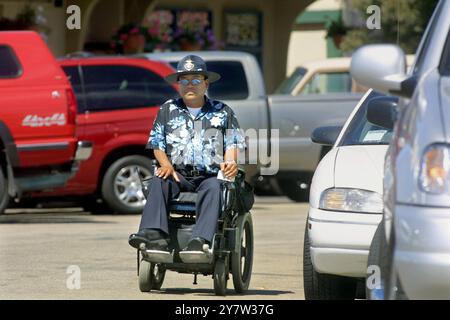 Capitola, Californie : Ben Irao, agent de police du stationnement, patrouille sur l'Esplanade à côté de la plage, portant son uniforme d'été optionnel, une chemise hawaïenne avec numéro de badge. L'idée est de rendre la police plus accessible. De nombreux résidents de Capitola se rendent à leur travail dans la Silicon Valley. 6 août 2001 Banque D'Images