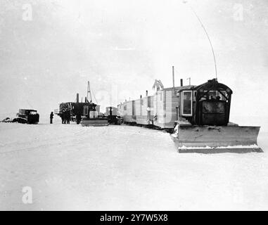 À LA RECHERCHE DE «L'OR NOIR» de L'ALASKA DERRIÈRE Un MUR DE GLACE : UNE STATION PÉTROLIÈRE AMÉRICAINE DANS LE CERCLE ARCTIQUE à des centaines de kilomètres dans le cercle arctique, où les températures de 50 en dessous sont communes et le sol reste gelé toute l'année, un bataillon de l'US Navy 'Seabees' prospecte pour le pétrole. Depuis les fenêtres de leurs huttes quonset faisant face à l'océan Arctique près de point Barrow, le sol le plus au nord des États-Unis sur ce continent, ils regardent sur une vue gelée où la glace polaire s'accumule, s'écrasant de l'océan. A jeté des millions de tonnes de glace sur la plage pour faire un mur gelé le long de l'ensemble de l'Arctique co Banque D'Images