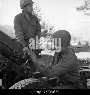 DÉFENSEURS DES AVANT-POSTES ÉLOIGNÉS DE LA FRONTIÈRE FRANÇAISE ITALIENNE DANS LES ALPES la 44e brigade américaine (alpine), avec d'autres unités, tient le front dans les Alpes, entre la France et l'Italie, depuis l'invasion de la Riviera. Peu spectaculaire et lointain, le travail accompli par l'artillerie de cette force alpine a été effectué à travers l'hiver amer dans des conditions difficiles, fréquemment dans ou au-dessus des nuages et toujours dans la neige. L'artillerie, les munitions et le ravitaillement devaient être transportés par train muletier et lorsque cela devint impossible, les hommes construisirent une ligne funiculaire entre les sommets des montagnes pour obtenir leur g Banque D'Images