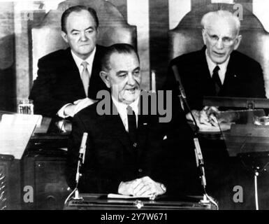 Johnson parle des droits de votionWashington DC, Etats-Unis : le Président Lyndon B Johnson (premier plan) , parle à une session conjointe du Congrès sur les droits de vote. Derrière lui se trouvent le vice-président Hubert Humphrey (à gauche) et le président de la Chambre, John McCormack. Il est tout à fait inhabituel qu'un président s'adresse personnellement au Congrès, sauf lorsqu'il prononce son message annuel sur l'état de l'union ou lorsqu'il parle de questions d'urgence nationale grave. Le Président s'est rendu au Congrès à l'invitation des dirigeants des partis démocrates et républicains le 15 mars 1965 Banque D'Images