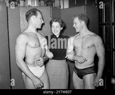 Avec une escorte HE-Man sur chaque bras Connie Lamb, de Battersea, pourrait bien sembler heureuse. Les puissants mâles sont des concurrents dans le concours Mr Universe, mis en scène au palladium de Londres par la National amateur Body Builders' Association demain. Sur la gauche, George Barbie, de l'armée américaine, de San Jose, Californie (il est stationné en Allemagne avec le 2nd Ballalion 8th Infantry Regiment), et sur la droite Wayne Gaffron, un expert en haltérophilie dont le domicile est Pittsburgh, Pennsylvanie, États-Unis. Soixante hommes forts des Nations du monde sont en compétition dans le concours. 10 juillet 1953 Banque D'Images