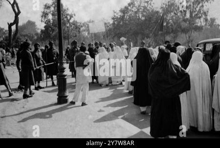 La Ligue musulmane a tenu des réunions de défiance à Lahore. Les dirigeants se sont dirigés vers le Secrétariat et, lorsque ces photos ont été prises, Begum Shah Nawaz et l'ex-ministre Shaukat Hyat Khan, récemment libérés, ont été arrêtés une deuxième fois. Il y a eu 62 arrestations. Des femmes musulmanes, principalement dans le purdah, ont pris part aux manifestations de défiance et des gaz lacrymogènes ont été utilisés pour disperser la foule. Vu ici des femmes musulmanes dans le purdah vers la route du Temple, Lahore, pendant les manifestations. (Légende originale) 8 février 1947 Banque D'Images