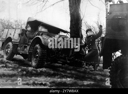 Des filles de l'ATS ont été formées comme chauffeurs de camions de l'armée au camp du Commandement du Nord. Le travail principal pour les filles est le transport , en convoi , des nouveaux camions vers des unités dans toute la Grande-Bretagne. Le cours de formation dure 3 semaines et les âges des filles varient entre 18 et 43 ans. Photo montre : un véhicule reconduit sur la route à l'aide d'un autre camion militaire le .31 janvier 1941 Banque D'Images