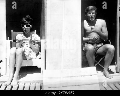 St Tropez, France : clowns entre les plans de son nouveau film ' deux pour la route ' , l'actrice Audrey Hepburn (à gauche) et l'acteur Albert Finney (à droite) font des gestes identiques ou presque l'un vers l'autre . Le couple chanceux se détendent dans des cabanes de plage sur la plage isolée de Beauvallon près de St Tropez , où le film est tourné sur place .10 juin 1966 Banque D'Images