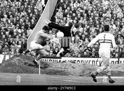 Istvan Geczi , le gardien hongrois , sauve contre David Herd de Manchester United (à gauche) lors de la demi-finale de la Coupe Inter-Cities Fairs Cup , deuxième match entre Manchester United et Ferencvaros de Hongrie , le 6 juin 1965 . Le match , dans lequel Crerand , Manchester United et Pat Orosz , moitié gauche de Ferencvaros , ont été expulsés du peloton à la 75e minute , s'est terminé par une victoire de 1-0 pour l'équipe hongroise le .10 juin 1965 Banque D'Images