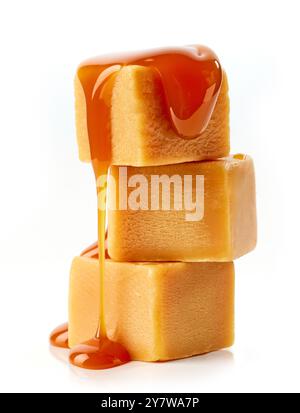 pile de bonbons au caramel et sauce caramel coulante isolés sur fond blanc Banque D'Images