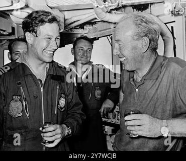 HMS Hermes , au large de Penang , Malaisie : célébrant avec champagne après leur long vol , le lieutenant-commandant John Nicholls ( à gauche ) de Halesworth , Sussex et l'amiral Sir Michael le Fanu , chef d'état-major de la marine et premier seigneur de mer . L'amiral le Fanu , vêtu d'une combinaison de vol sans insignes de rang , accompagnait le Lt Nicholls dans l'un des quatre Buccaneers du 803e Escadron de la Royal Navy Air Station à Lossiemouth en Écosse , jusqu'au HMS Hermes ( porte-avions ) dans l'océan Indien au large de la côte ouest de la Malaisie . Le but de l'exercice était de tester la capacité de la Royal Navy à se soumettre Banque D'Images