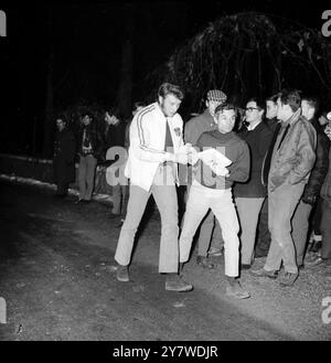 Grenoble , lors de la Monaco -Chambéry - Monaco Alpine Night - tour du Rallye de Monte Carlo populaire chanteur pop français Johnny Hallyday ( au centre ) a dû signer l'égister de rallye au Col de Fence - il a été assiégé par des fans admirateurs pour son autographe le 20 janvier 1967 Banque D'Images