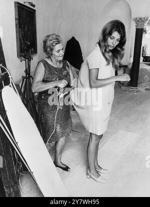 L'actrice canadienne Joanna Shimkus se fait repasser sa robe entre deux scènes de tournage pour le film 'Go Forth' qui met en vedette Elizabeth Taylor et son mari Richard Burton. Dans le film Joanna joue le rôle de la secrétaire de Miss Taylor. 9 octobre 1967 Banque D'Images