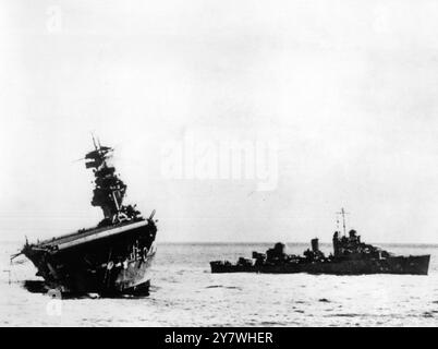 Ses canons pointaient toujours avec défiance vers le ciel , l'USS Yorktown faisant fortement escale sur le côté bâbord après un brutal assaut par des bombardiers japonais et des avions torpilleurs lors de la bataille de Midway le 4 juin 1942 Banque D'Images